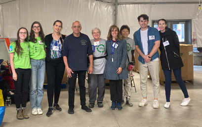 A group photo of 9 WRG volunteer members, including GNN members, from diverse backgrounds standing together and smiling inside the June 2023 REmarket tent