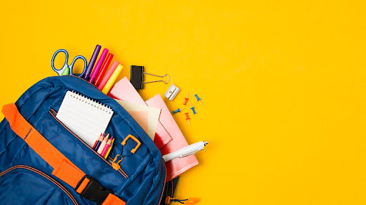 Photo of various colorful school supplies, including a backpack, pens, pencil crayons, and scissors